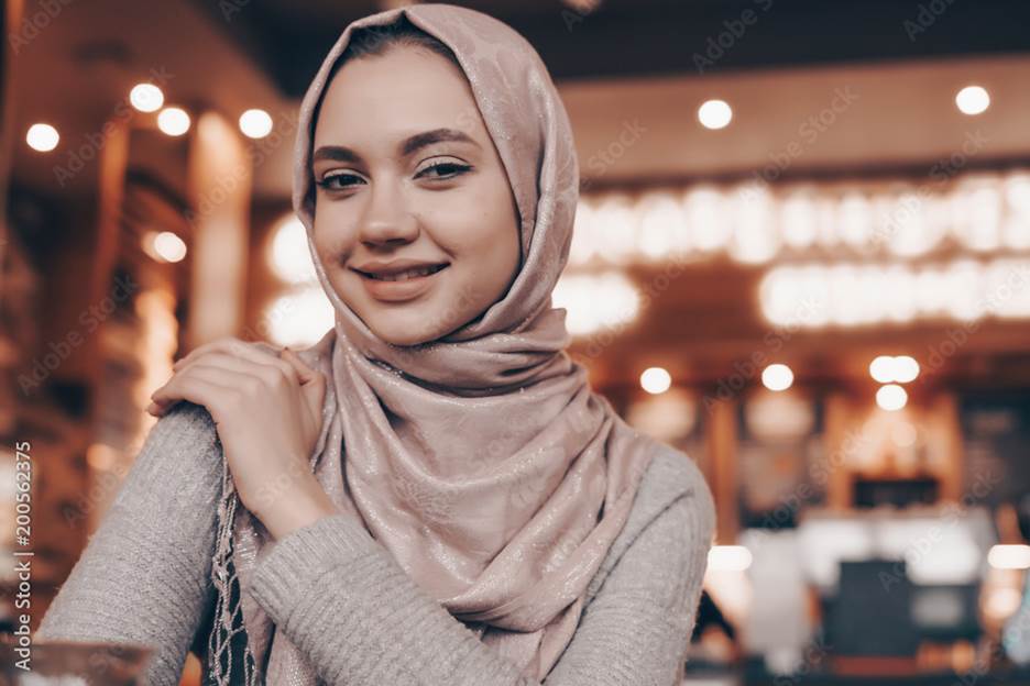 beautiful smiling Arab girl in hijab sits in cafe in oriental style Stock Photo | Adobe Stock