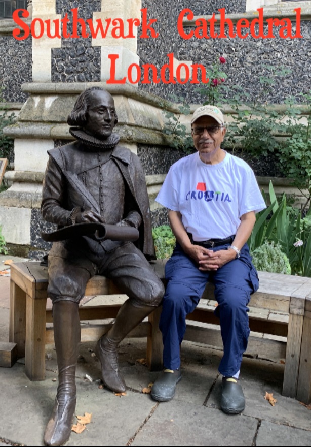 A person sitting next to a statue Description automatically generated