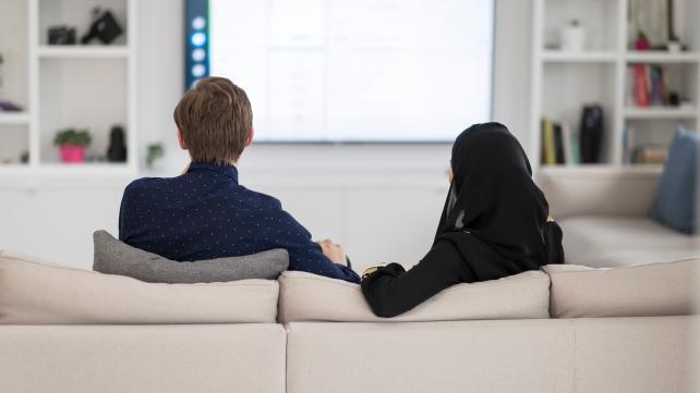 A person sitting on a couch Description automatically generated with low confidence