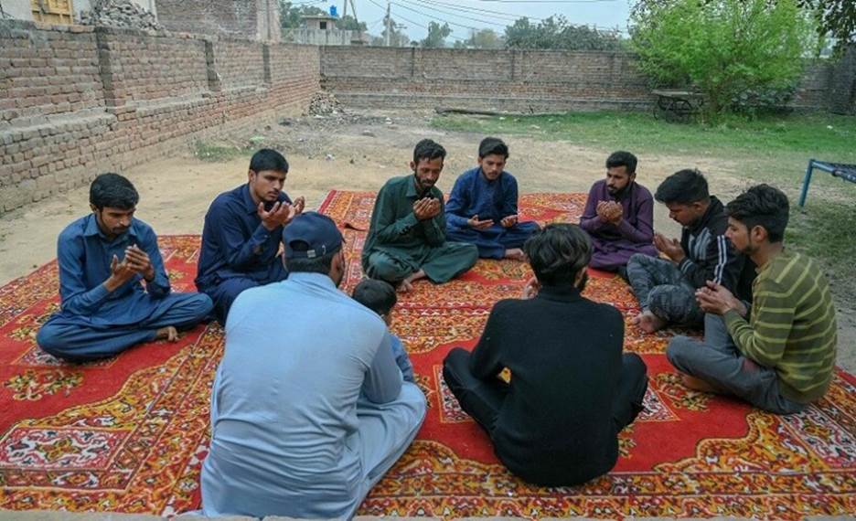 In this picture taken on March 2, 2023, mourners pray for Muhammad Nadeem, near his house in Gujrat district of Punjab province, who died in Libya boat capsizing along with other migrants. — AFP