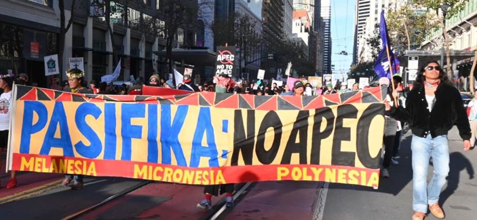 A group of people holding a banner Description automatically generated