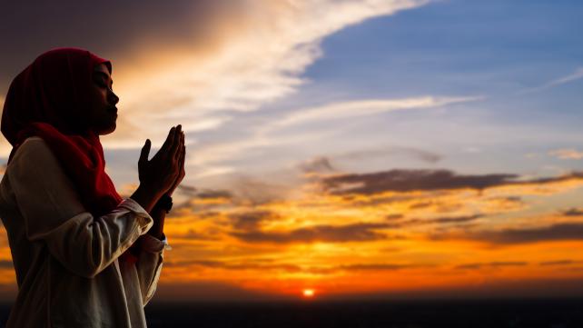 A person praying with their hands together Description automatically generated