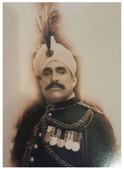 A person with a mustache wearing a turban and a white turban Description automatically generated