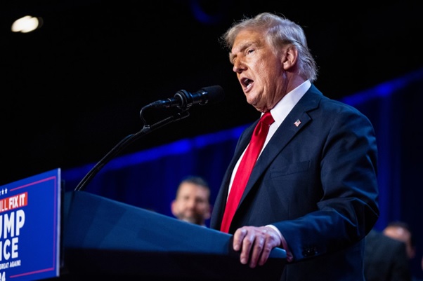 A person in a suit speaking into a microphone  AI-generated content may be incorrect.