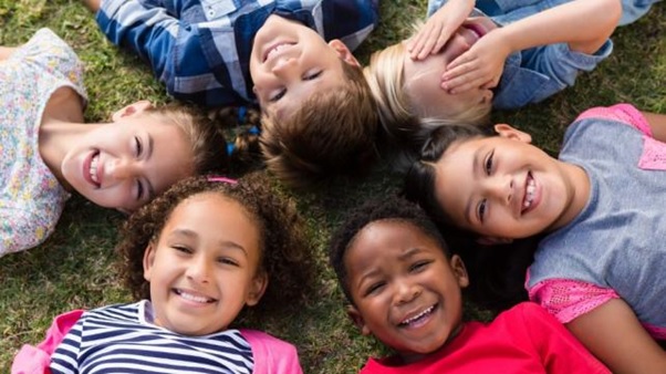 A group of children lying in a circle  AI-generated content may be incorrect.