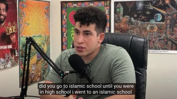 A person sitting in a chair with a microphone  AI-generated content may be incorrect.