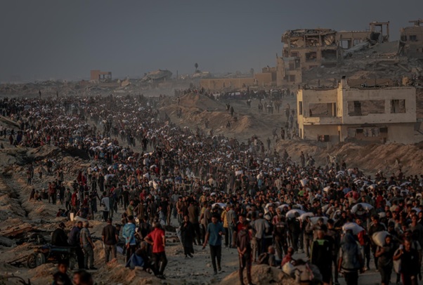 Hundreds of people walking on a road at sunset