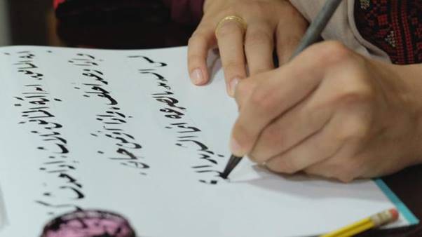 A person writing on a piece of paper  AI-generated content may be incorrect.