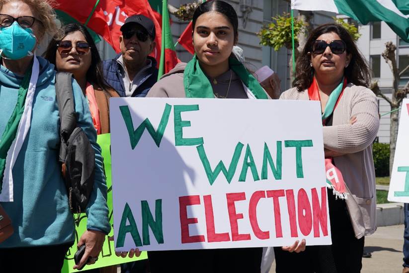 A group of people holding a sign Description automatically generated