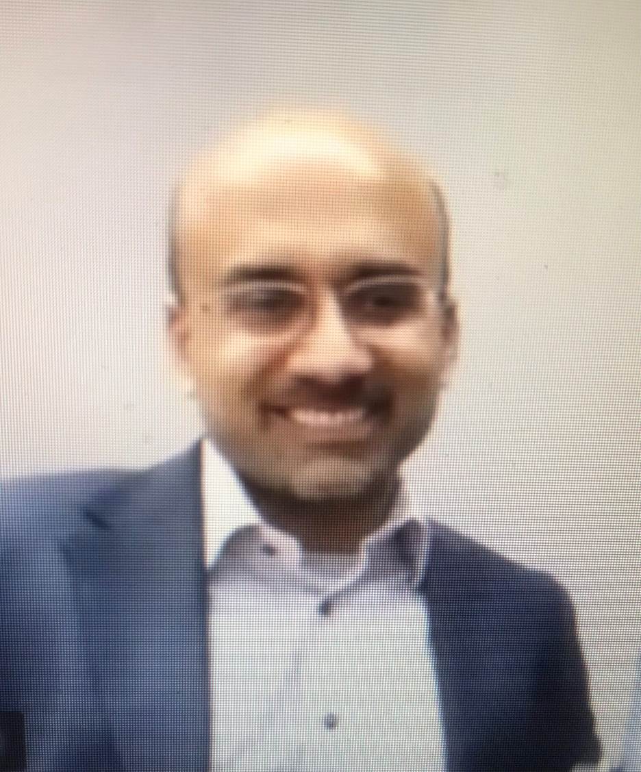 A person smiling for the camera Description automatically generated with medium confidence
