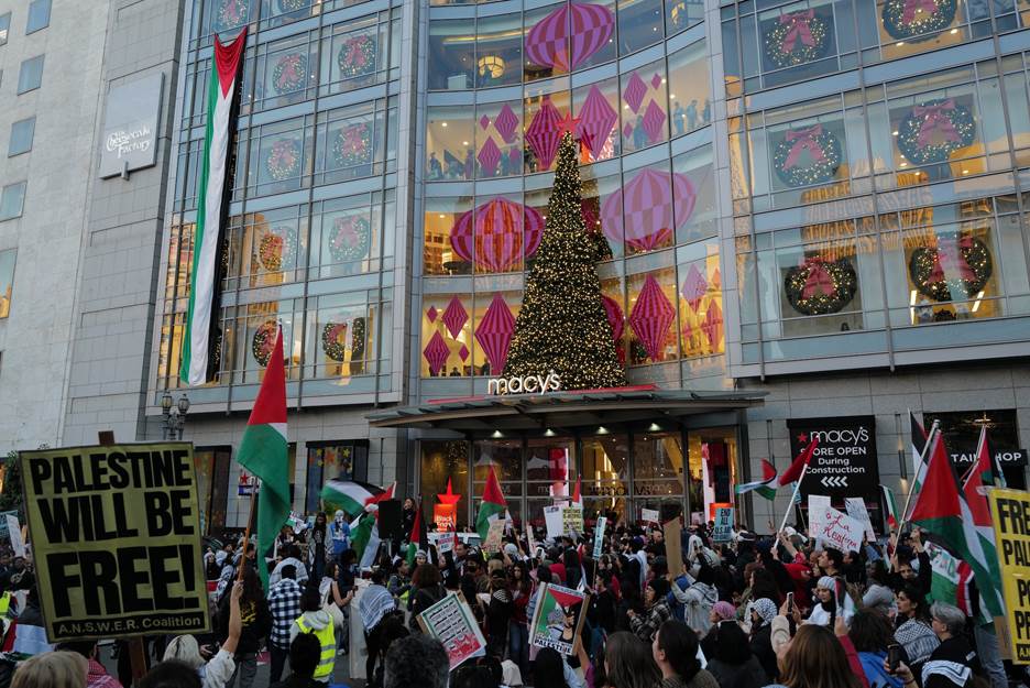 A group of people protesting in front of a building Description automatically generated