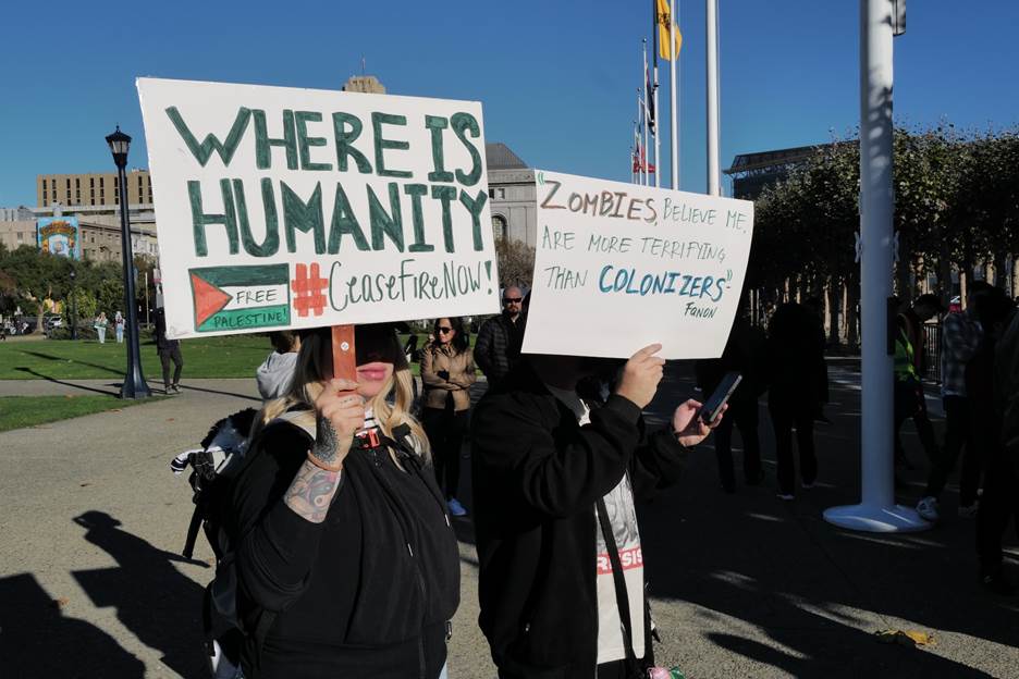 A group of people holding signs Description automatically generated