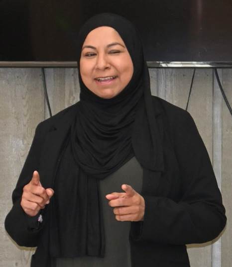 A person wearing a black head scarf Description automatically generated