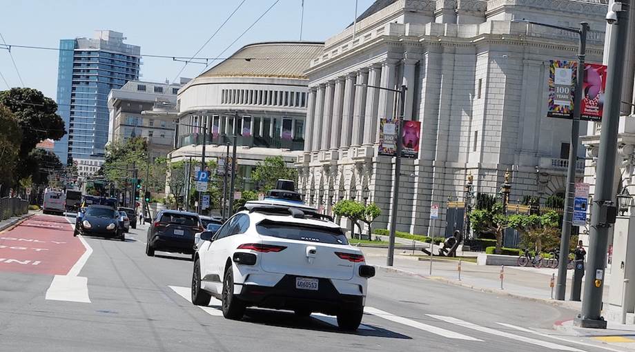 A white car on the street Description automatically generated