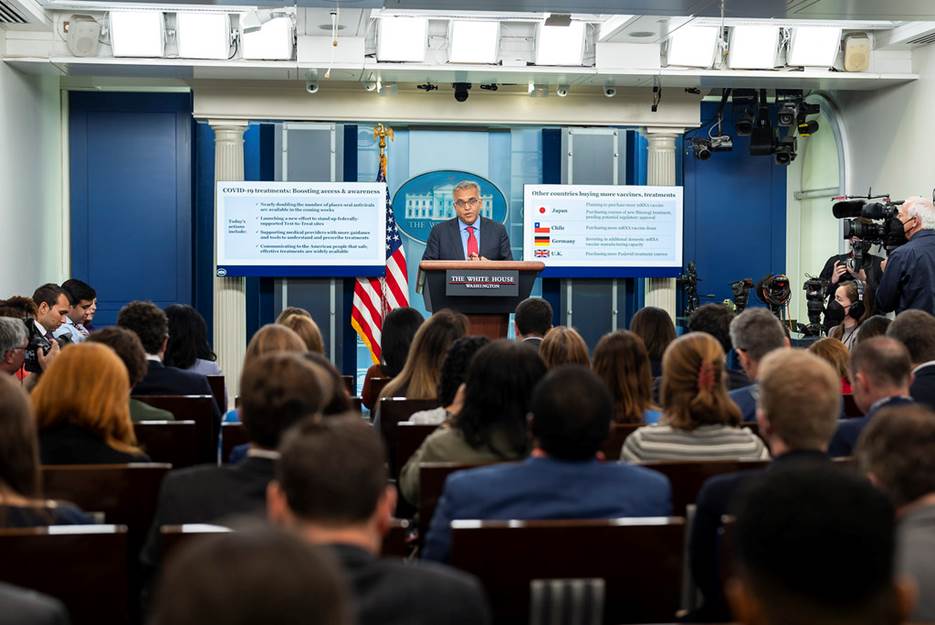 A person standing at a podium with a crowd of people in the background Description automatically generated with low confidence