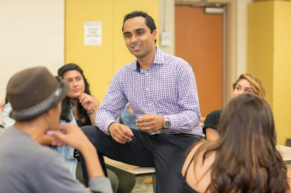 A person sitting in a circle with a group of people Description automatically generated with medium confidence