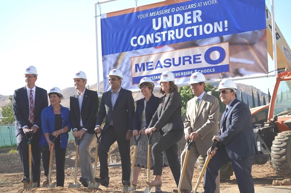 A group of people wearing hard hats holding shovels Description automatically generated with medium confidence