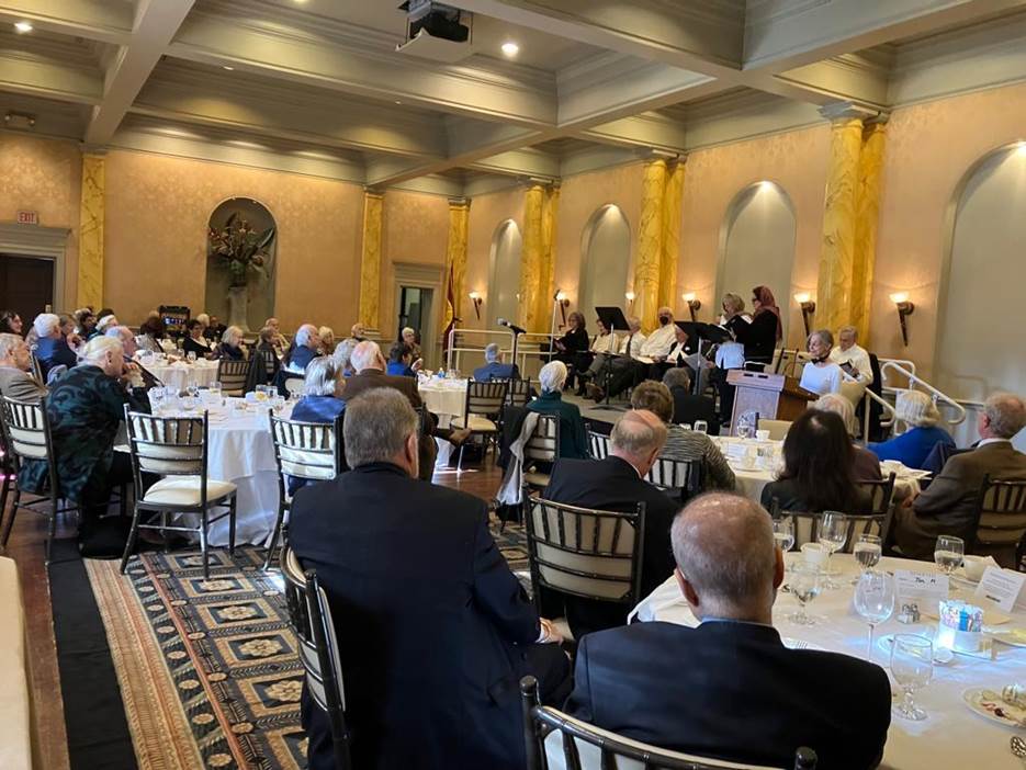 A group of people sitting at tables in a room Description automatically generated