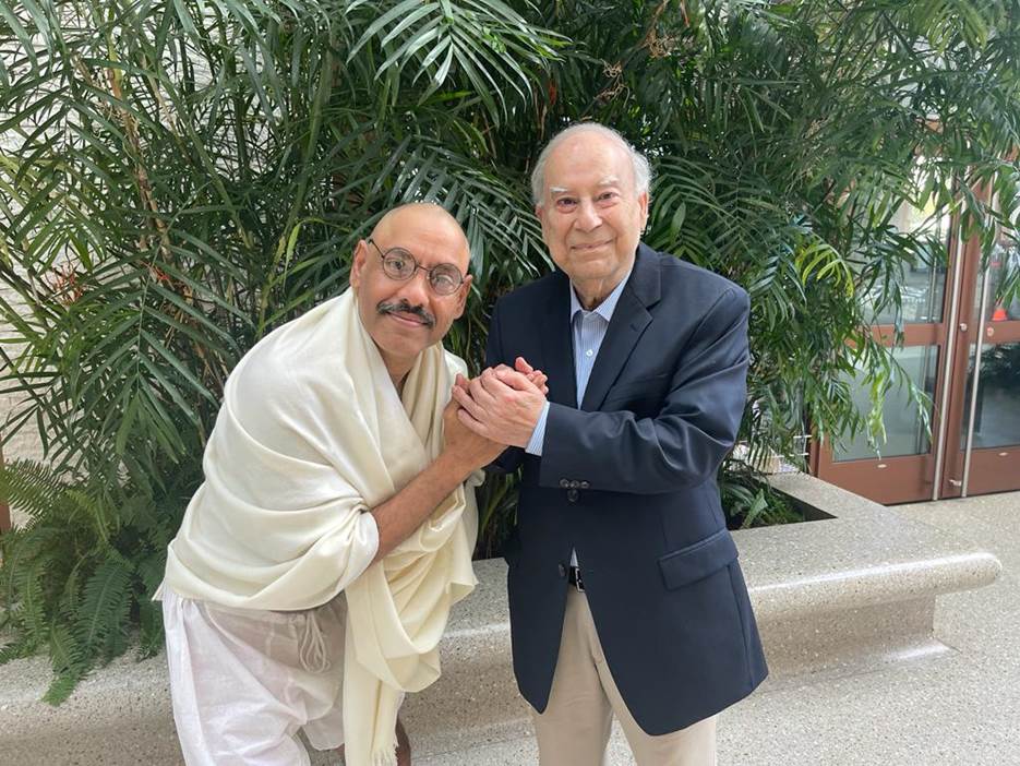 Two men holding hands and posing for the camera Description automatically generated