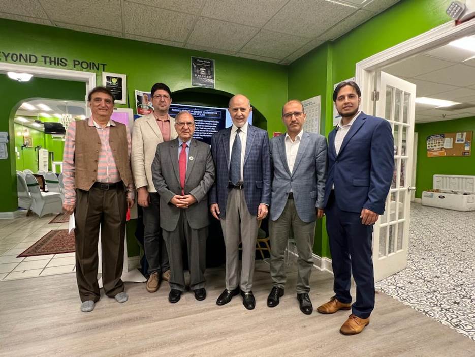 A group of men standing in a room Description automatically generated