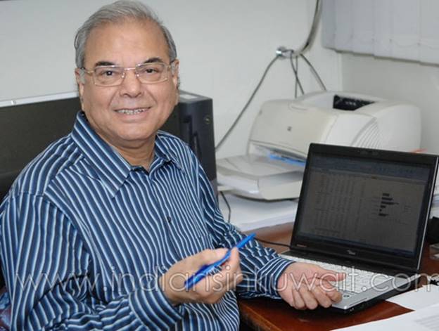 A person sitting at a desk with a computer and a pen Description automatically generated