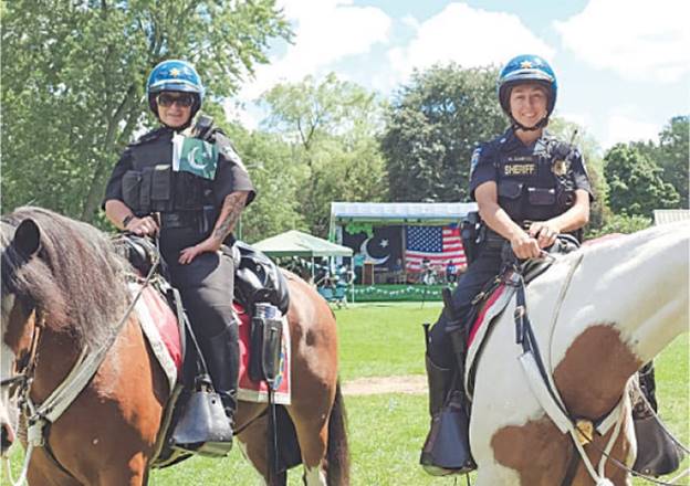 Mounted officers display Pakistani flags during the Independence Day event.—Photo by the writer