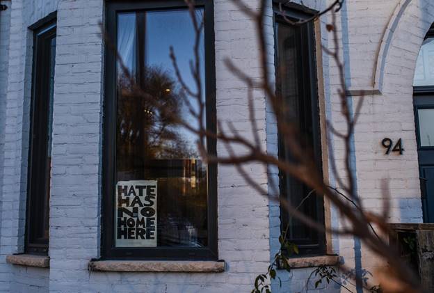 A hate has no home here sign is posted in the window of a residence