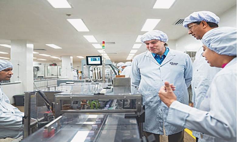 US diplomat Andrew Schofer watches work at a pharmaceutical firm in Karachi.—Dawn
