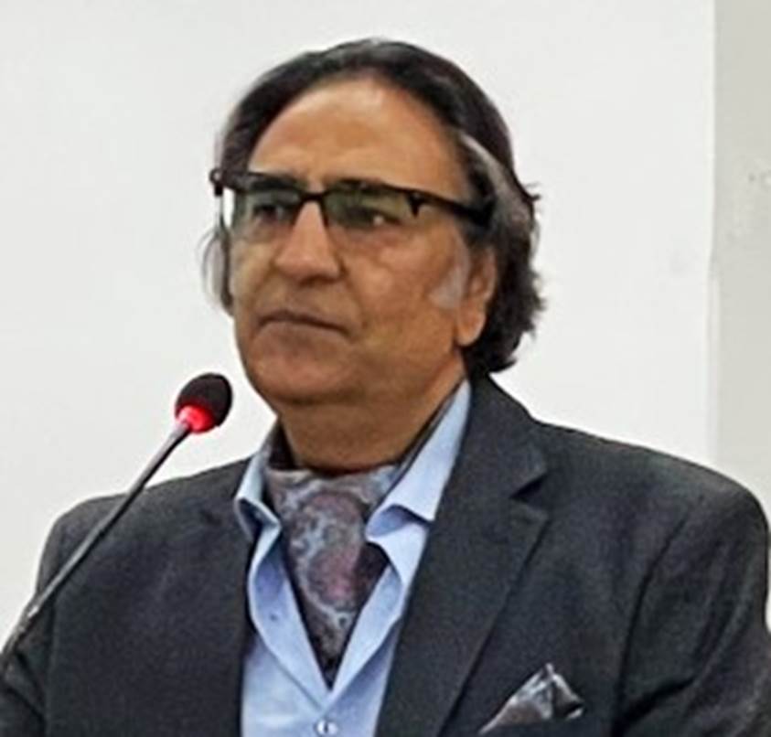 A person in a suit and glasses Description automatically generated