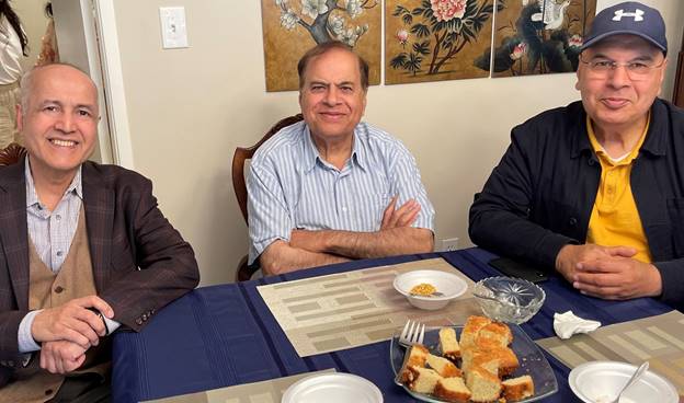 A group of men sitting at a table Description automatically generated