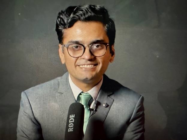 A person in a suit and tie Description automatically generated