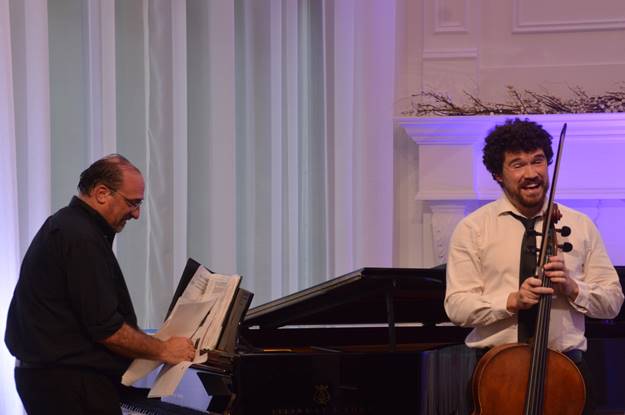 A group of men playing a musical instrument Description automatically generated