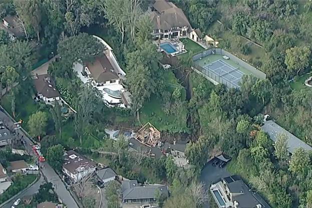 Aerial view of a large house surrounded by trees Description automatically generated