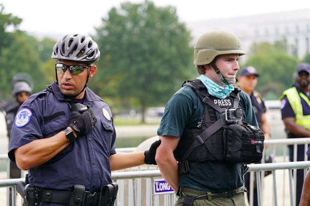A police officer and a person in helmets Description automatically generated with medium confidence