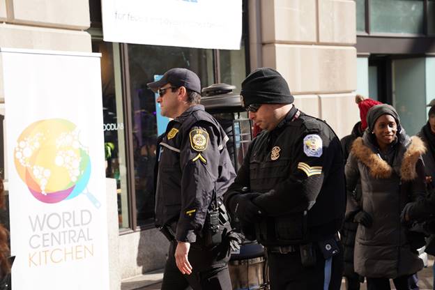 A group of police officers walking on the street Description automatically generated