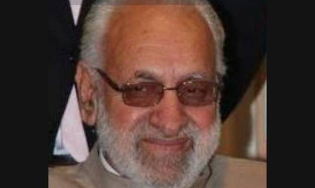 A person with glasses smiling Description automatically generated