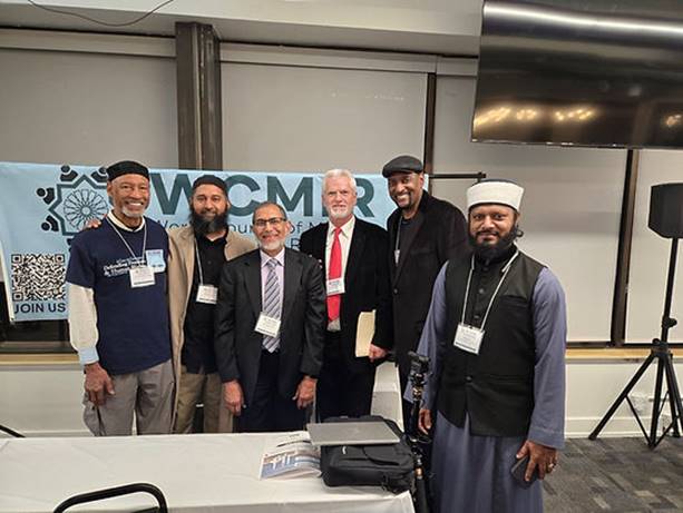 A group of men standing in front of a table Description automatically generated