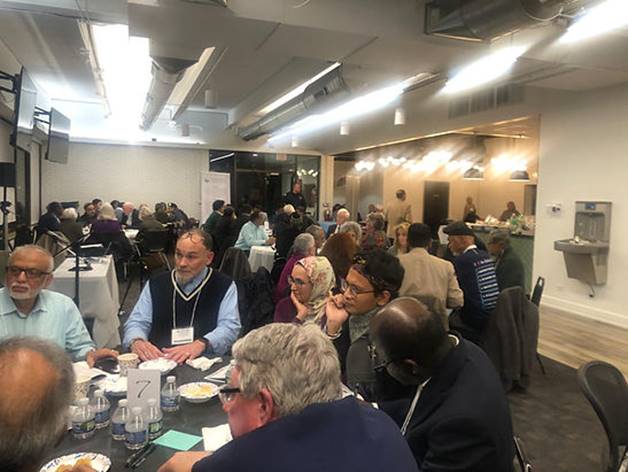 A group of people sitting at tables Description automatically generated
