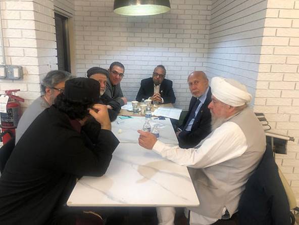 A group of men sitting around a table Description automatically generated