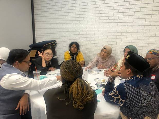 A group of people sitting around a table Description automatically generated