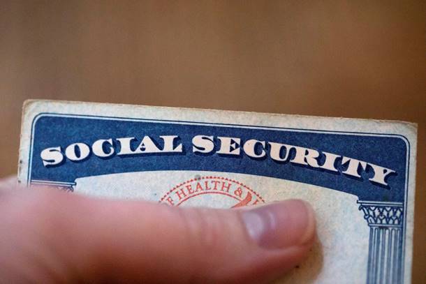 A finger holding a social security card Description automatically generated