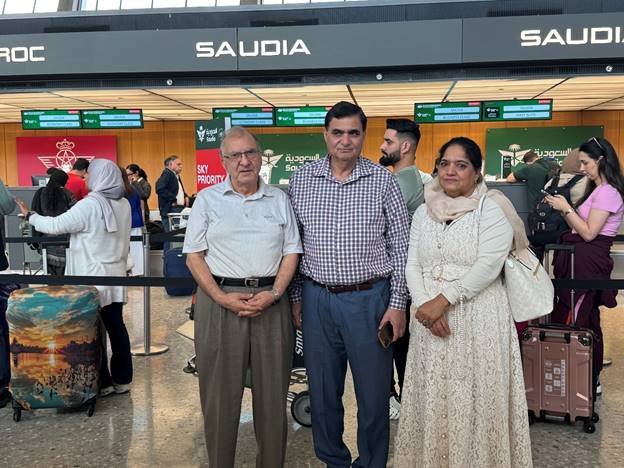 A group of people standing in an airport Description automatically generated