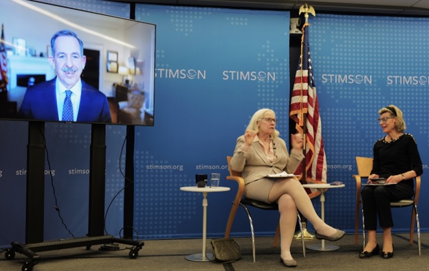 A person sitting in a chair in front of a flag AI-generated content may be incorrect.