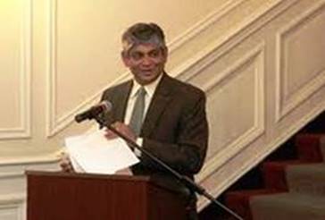 A person standing at a podium with a microphone  AI-generated content may be incorrect.