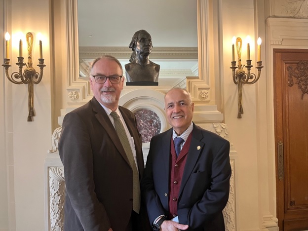 Two men standing in front of a statue  AI-generated content may be incorrect.