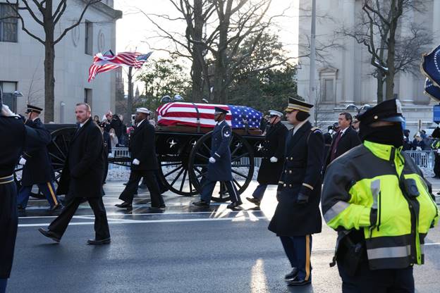 A funeral procession with a coffin Description automatically generated