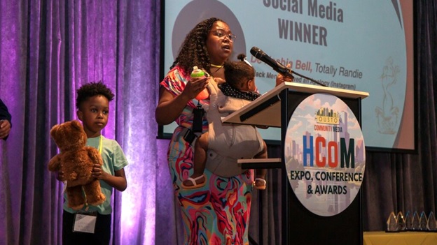 A person holding a baby at a podium  AI-generated content may be incorrect.