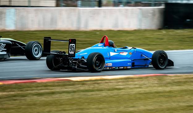A blue race car on a track  AI-generated content may be incorrect.