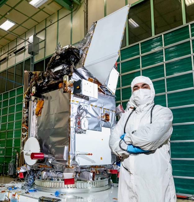 A person in white protective gear standing next to a large object  AI-generated content may be incorrect.