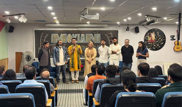 A group of people standing in a room with a chalkboard behind them  AI-generated content may be incorrect.